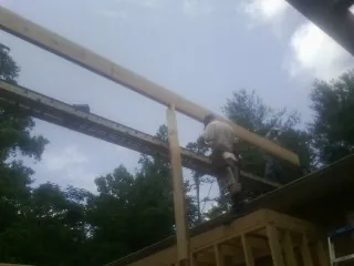 Carpenter setting a ridge beam over a new addition frame — Ice Dam Removal by Roofing Brothers in Wymore