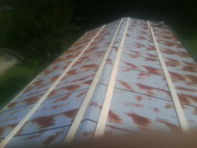 Rusted metal roof panels with new wood purlins before replacement — Storm Damage Roof Repair in Wymore by Roofing Brothers