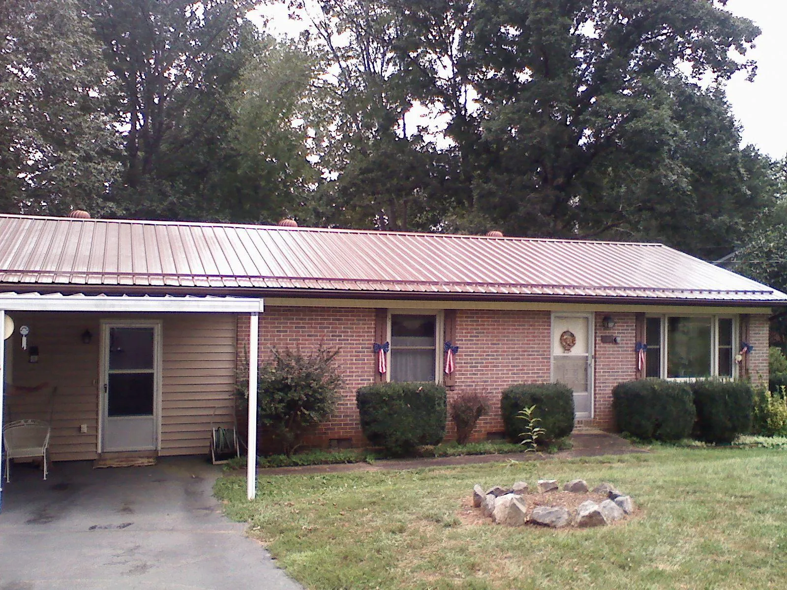 Bronze metal roof and carport on a brick ranch home — Roof Repair work by our crew in Wymore